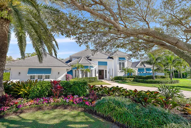 a front view of a house with a yard and potted plants