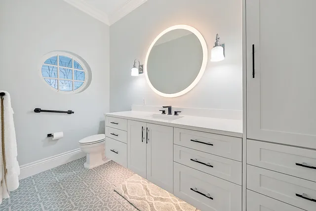a kitchen with white cabinets and sink