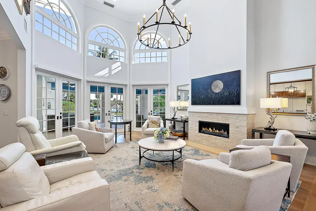 a living room with furniture a fireplace and a chandelier