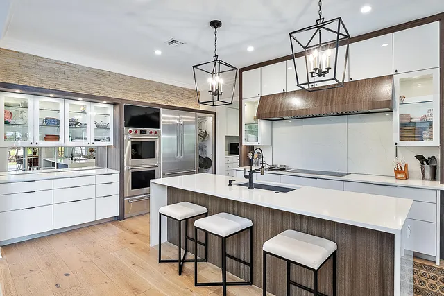 a kitchen with a dining table chairs stainless steel appliances and cabinets