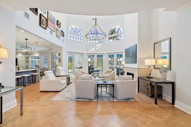 a very nice looking living room with a dining table a sink and a chandelier