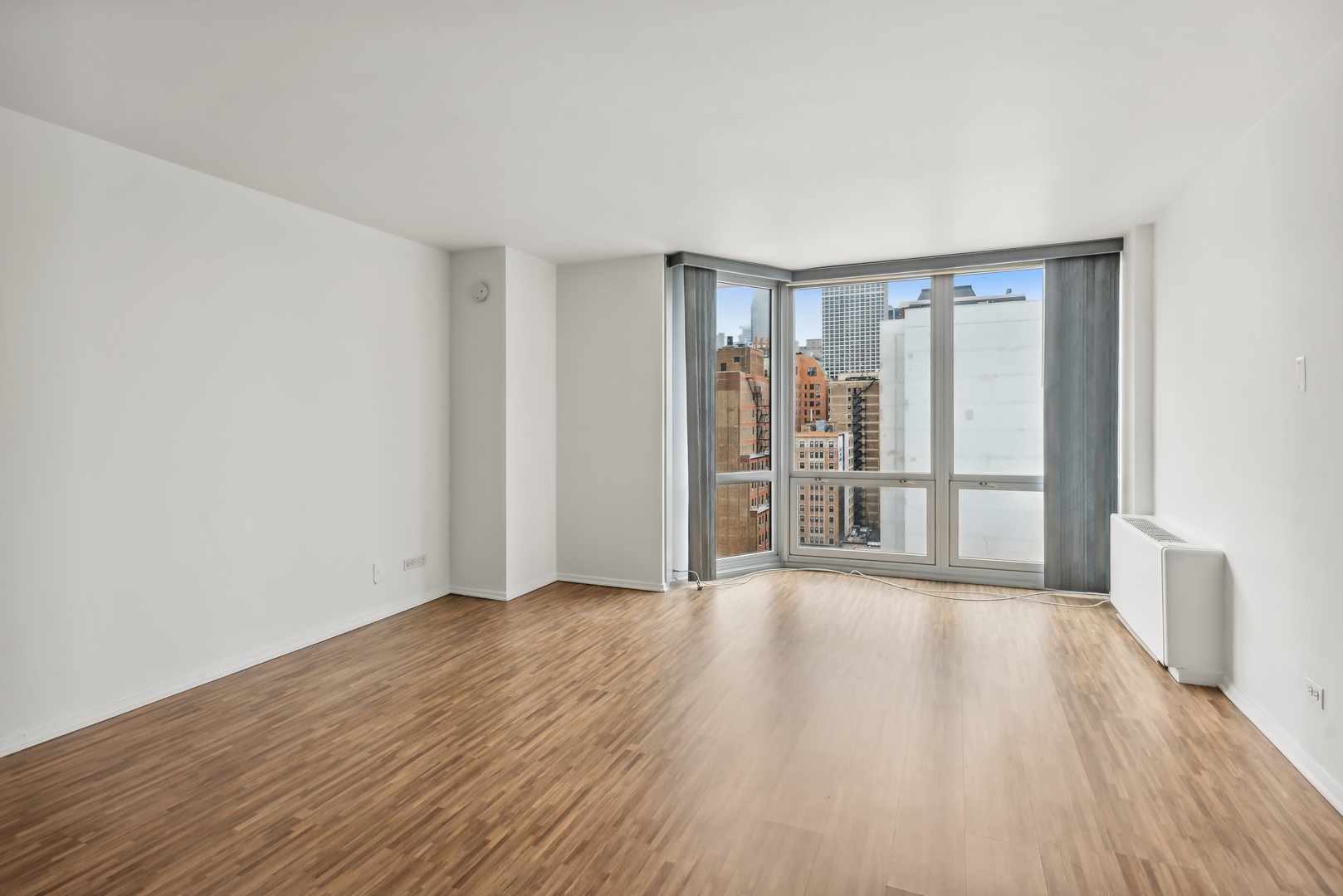 21 West Goethe Street, Unit 17K Chicago, IL 60610 - Photo 4 of 16 a view of an empty room with wooden floor and a window
