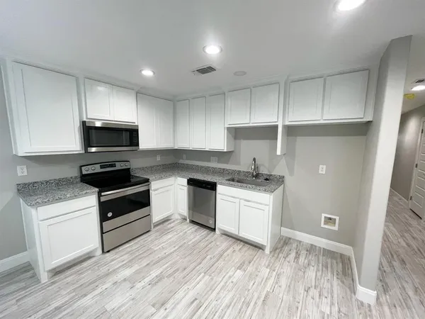 a kitchen with granite countertop a stove and a sink