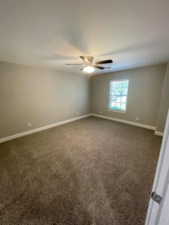 an empty room with windows and ceiling fan view