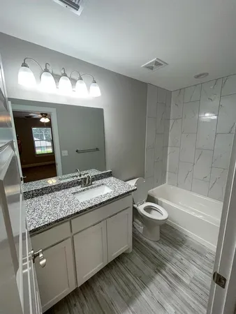 a bathroom with a granite countertop sink toilet and shower