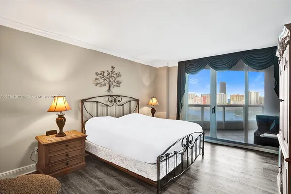 a bedroom with a large bed and a wooden floor