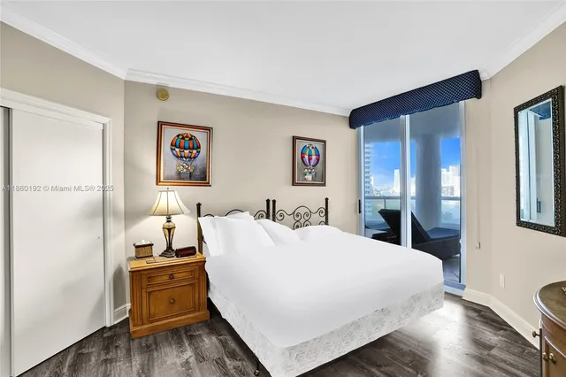 a large bedroom with a bed and wooden floor