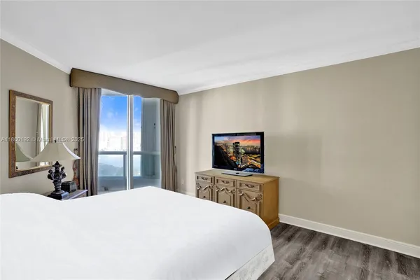 a bedroom with a bed and a flat screen tv