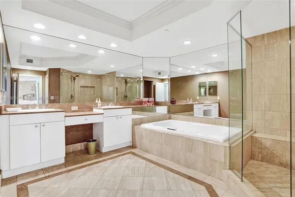 a large white kitchen with a white kitchen island a sink a stove and a refrigerator