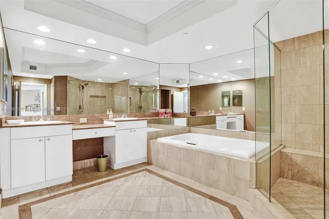 a large white kitchen with a white kitchen island a sink a stove and a refrigerator