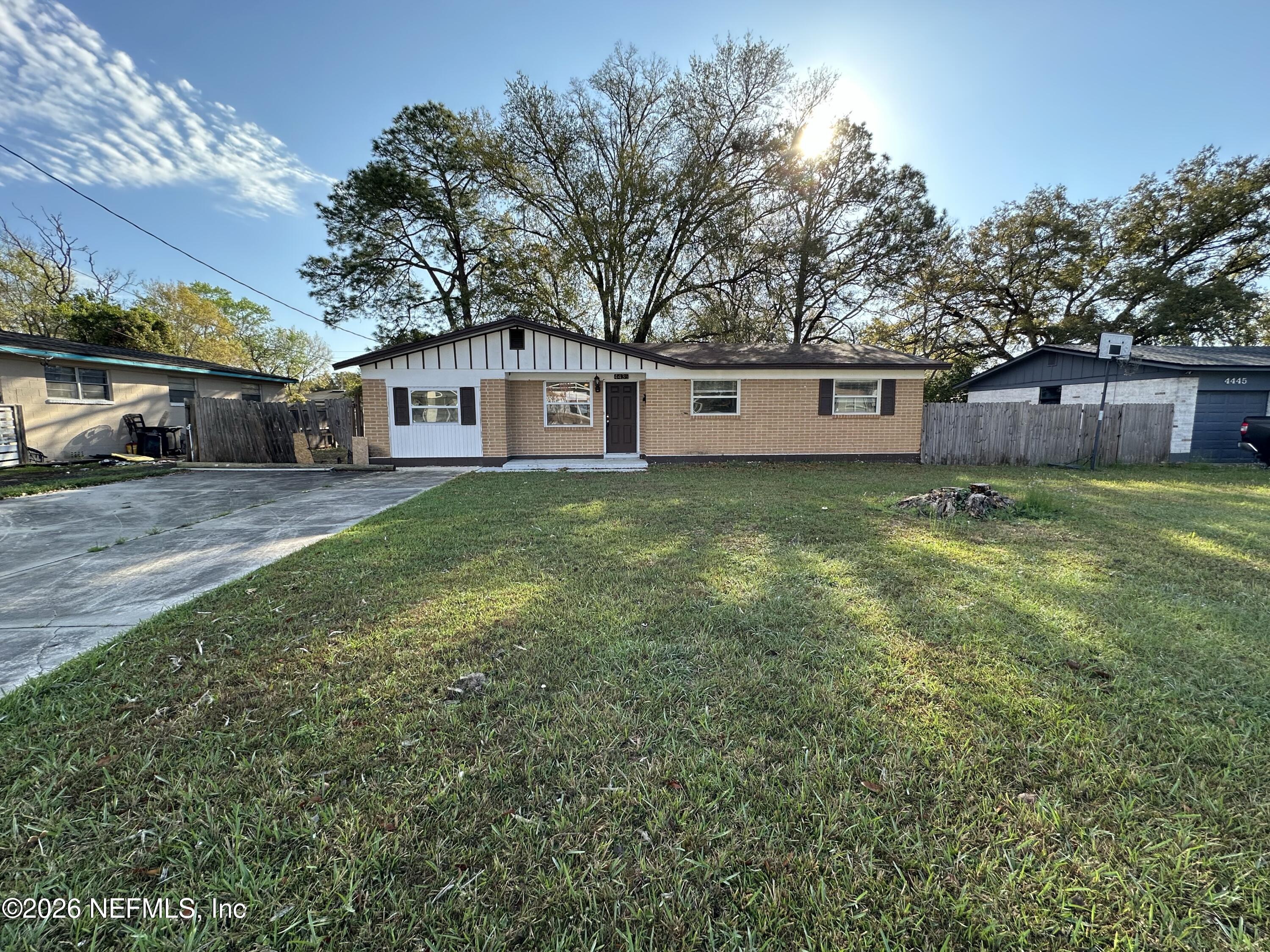 a view of a yard with a house and a large tree