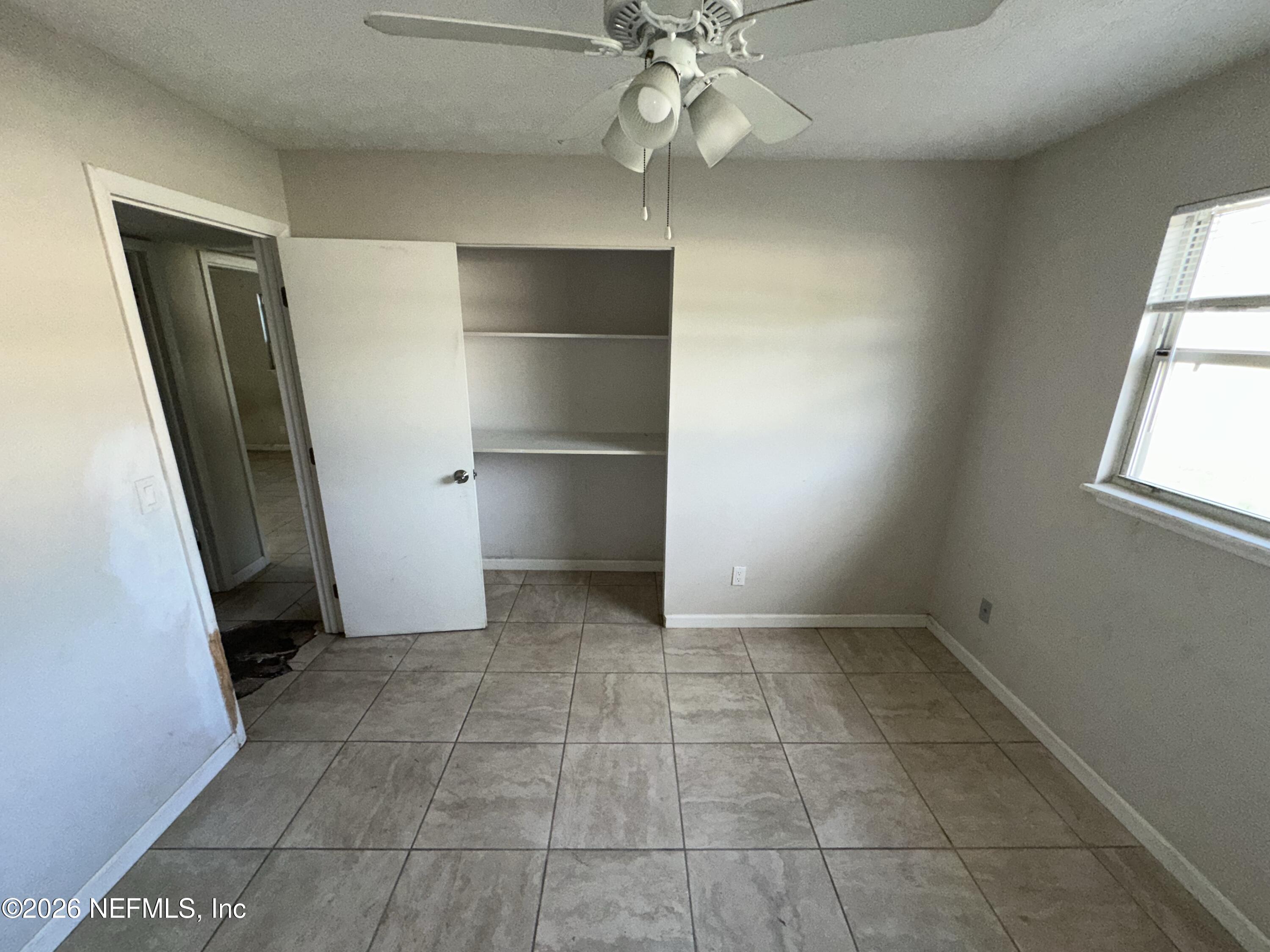 4435 Rainer Road Jacksonville, FL 32210 - Photo 8 of 14 an empty room with a fireplace and windows