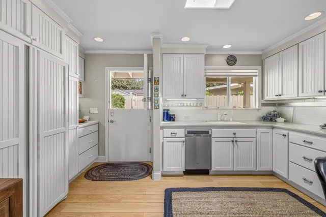 a kitchen with a refrigerator and white cabinets