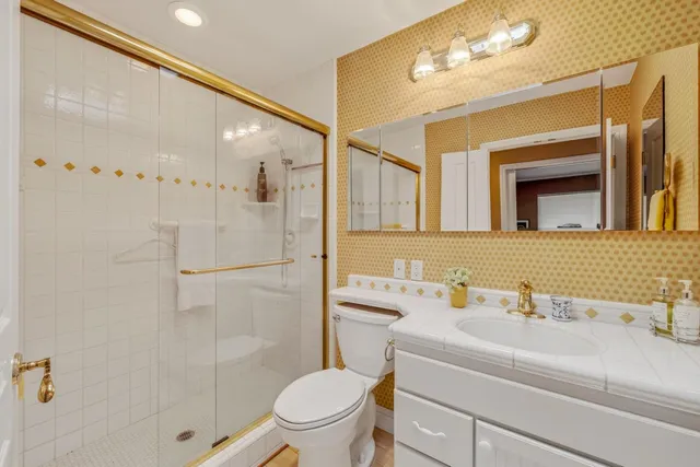 a bathroom with a sink a toilet and shower