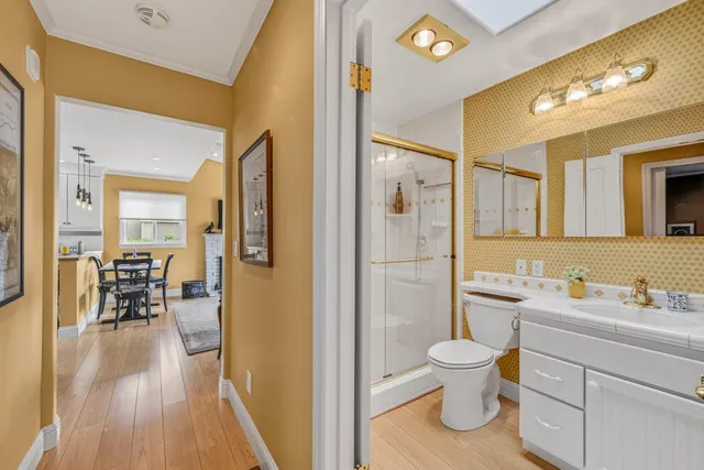 a bathroom with a sink a toilet a mirror and shower