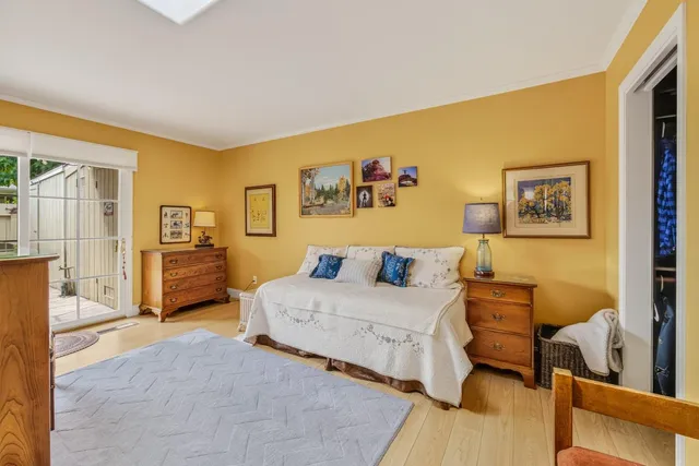 a spacious bedroom with a bed a couch and paintings on the wall