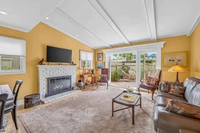 a living room with furniture a fireplace and a flat screen tv