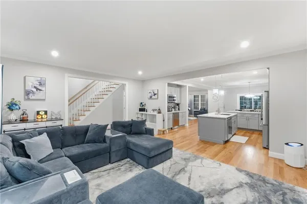 a living room with furniture and view of kitchen