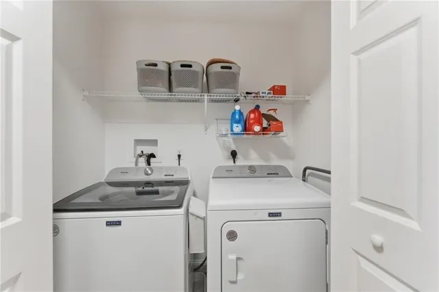 a utility room with sink dryer and washer
