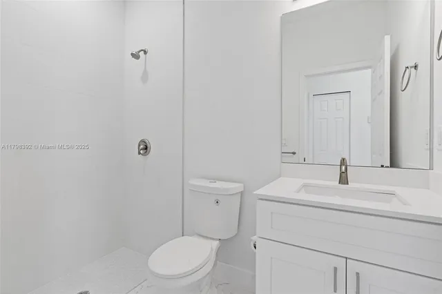 a bathroom with a toilet sink vanity and mirror