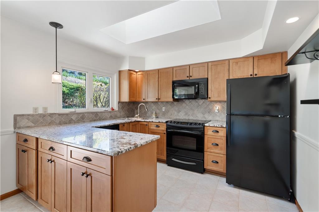 227 Old Clairton Road Pittsburgh, PA 15236 - Photo 7 of 22 a kitchen with stainless steel appliances granite countertop a refrigerator a sink a stove a microwave and island