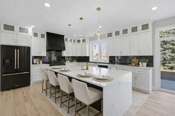 a kitchen with a sink stainless steel appliances and white cabinets