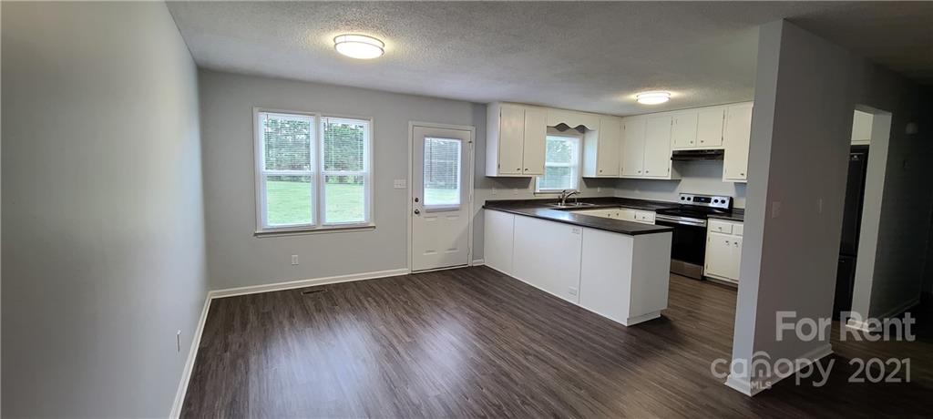 3560 Boggs Road Claremont, NC 28610 - Photo 2 of 15 a kitchen with granite countertop a stove a sink and a refrigerator