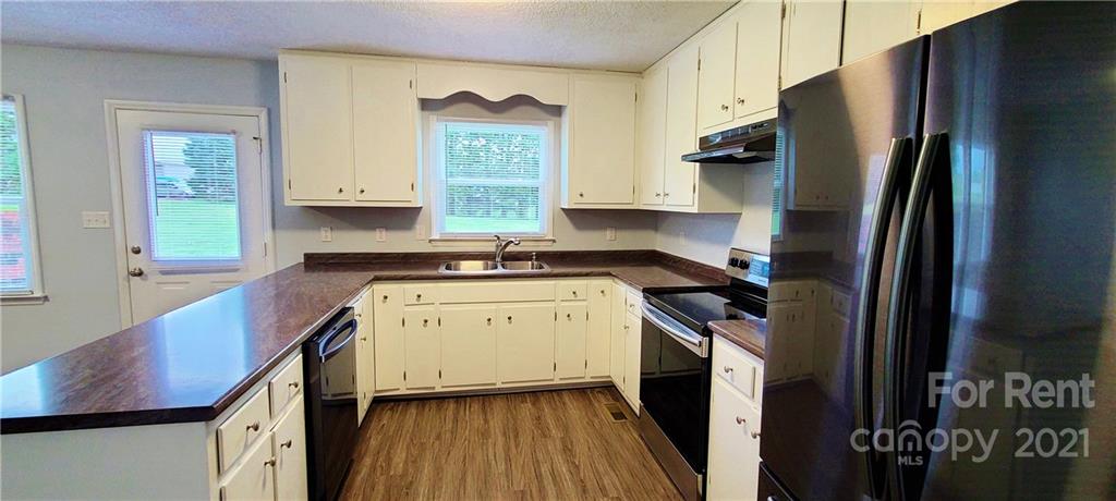 3560 Boggs Road Claremont, NC 28610 - Photo 7 of 15 a kitchen with a refrigerator a stove a sink and a window