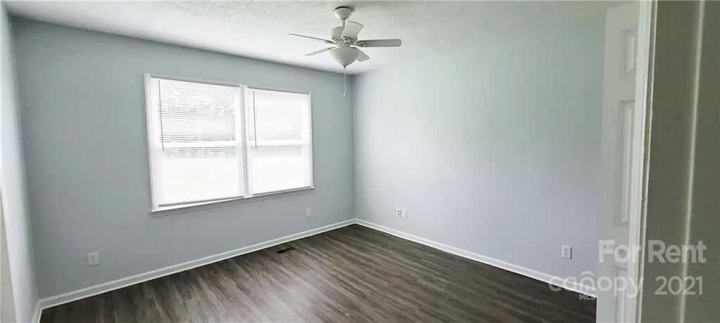3560 Boggs Road Claremont, NC 28610 - Photo 9 of 15 an empty room with wooden floor ceiling fan and windows