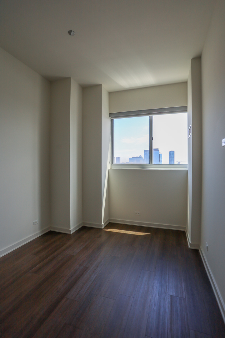 910 West Huron Street, Unit 1310 Chicago, IL 60642 - Photo 11 of 25 an empty room with wooden floor and windows