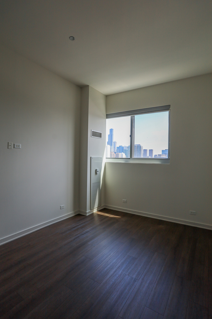 910 West Huron Street, Unit 1310 Chicago, IL 60642 - Photo 15 of 25 an empty room with wooden floor and windows