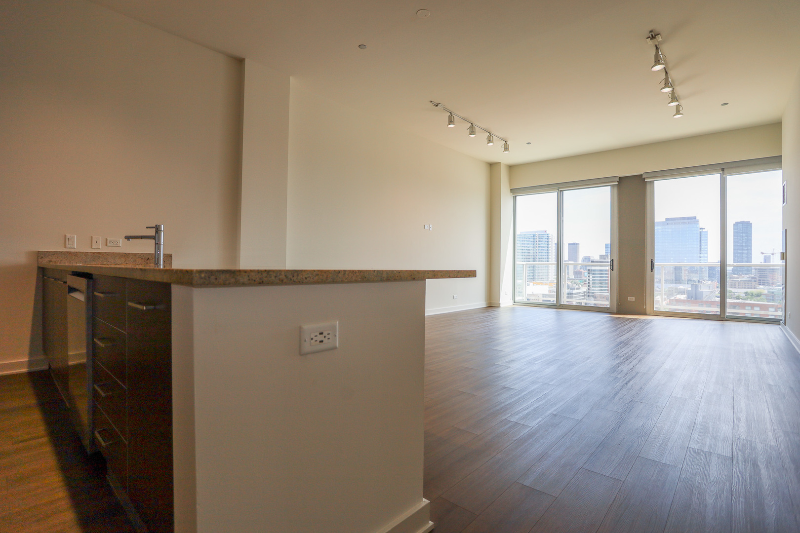 910 West Huron Street, Unit 1310 Chicago, IL 60642 - Photo 3 of 25 a view of a kitchen with a sink and wooden floor