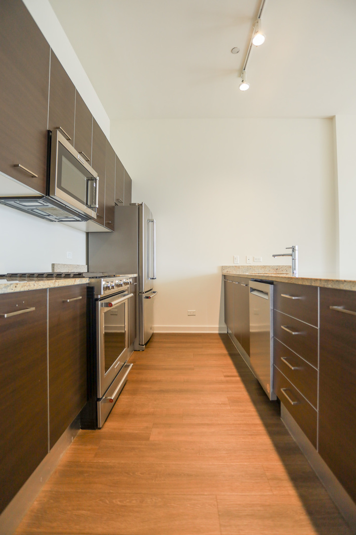 910 West Huron Street, Unit 1310 Chicago, IL 60642 - Photo 4 of 25 a kitchen with stainless steel appliances a stove and a refrigerator