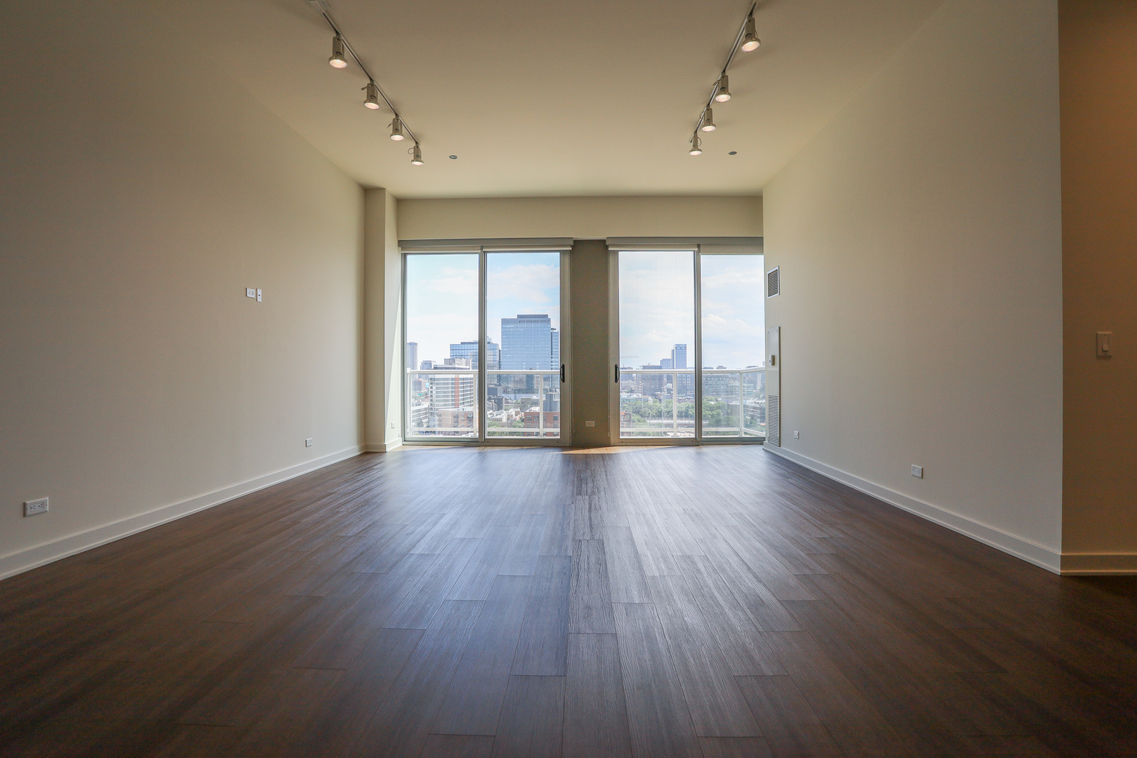 910 West Huron Street, Unit 1310 Chicago, IL 60642 - Photo 5 of 25 an empty room with wooden floor and windows
