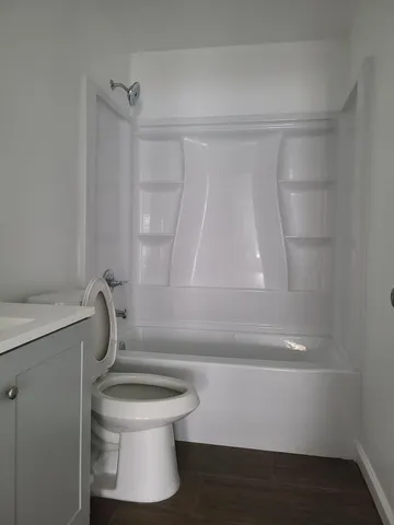 a bathroom with a shower a toilet and sink