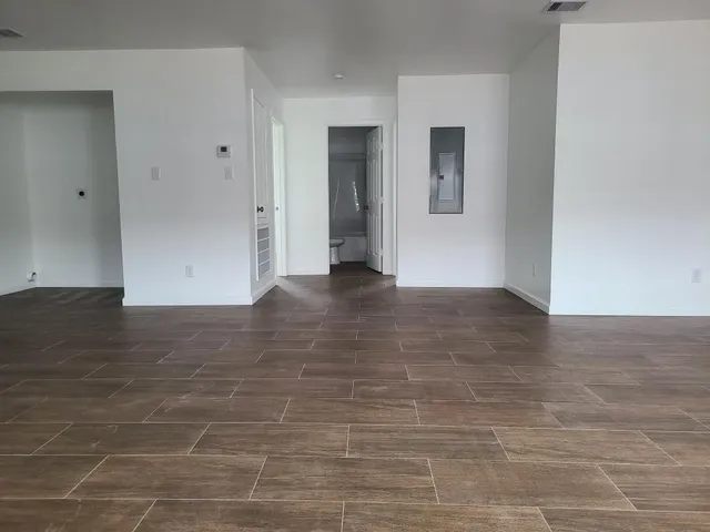 a view of empty room with wooden floor