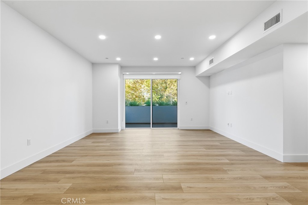 12078 Guerin Street, Unit 101 Studio City, CA 91604 - Photo 2 of 10 a view of an empty room with wooden floor and a window