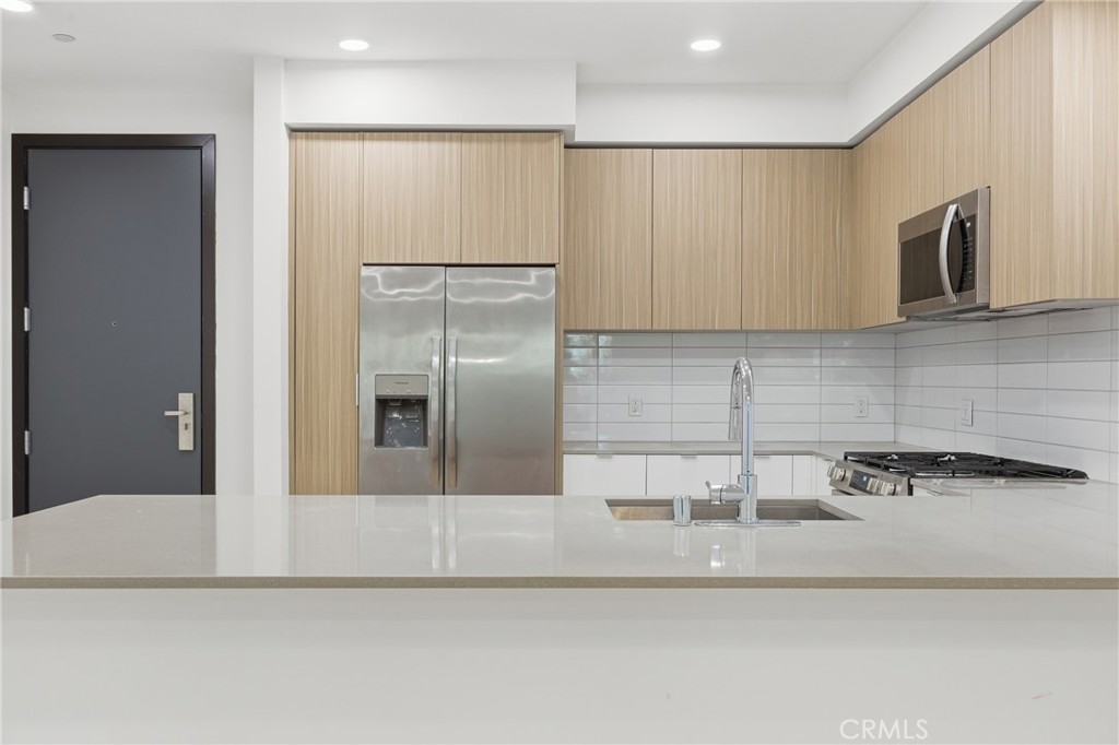 12078 Guerin Street, Unit 101 Studio City, CA 91604 - Photo 4 of 10 a kitchen with stainless steel appliances granite countertop a refrigerator a sink a stove and white cabinets