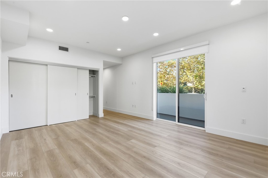 12078 Guerin Street, Unit 101 Studio City, CA 91604 - Photo 6 of 10 a view of an empty room with wooden floor and a window