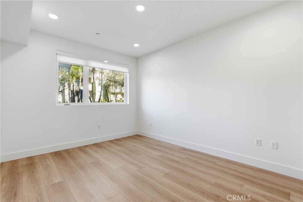 12078 Guerin Street, Unit 101 Studio City, CA 91604 - Photo 8 of 10 an empty room with wooden floor and window