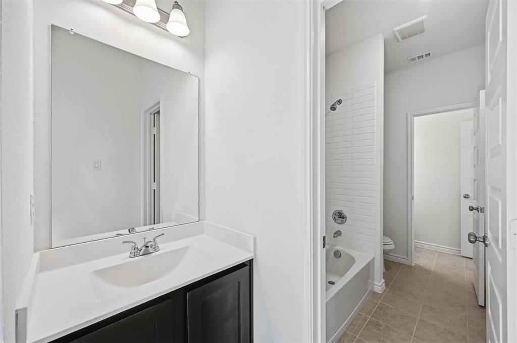 400 Wrangler Lane, Unit 400 Denton, TX 76209 - Photo 12 of 18 a bathroom with a double vanity sink and mirror