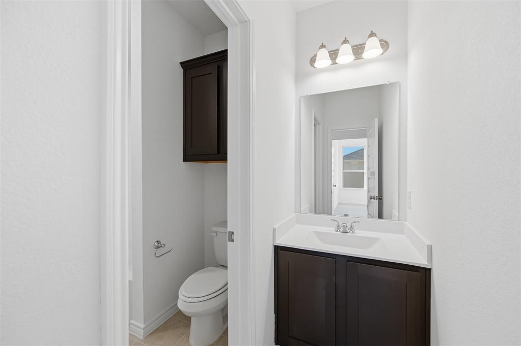400 Wrangler Lane, Unit 400 Denton, TX 76209 - Photo 17 of 18 a bathroom with a toilet sink and mirror