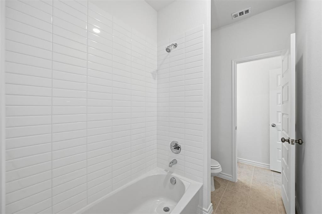 400 Wrangler Lane, Unit 400 Denton, TX 76209 - Photo 18 of 18 a bathroom with a bathtub