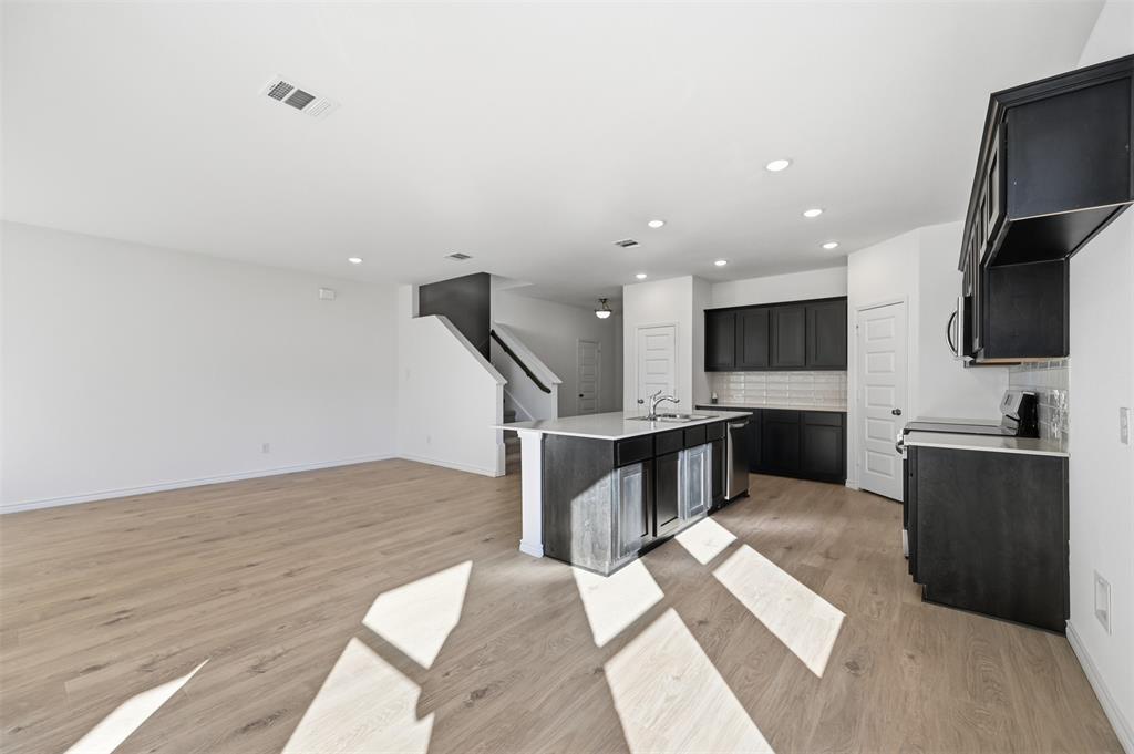 400 Wrangler Lane, Unit 400 Denton, TX 76209 - Photo 3 of 18 a kitchen with stainless steel appliances kitchen island sink refrigerator and stove