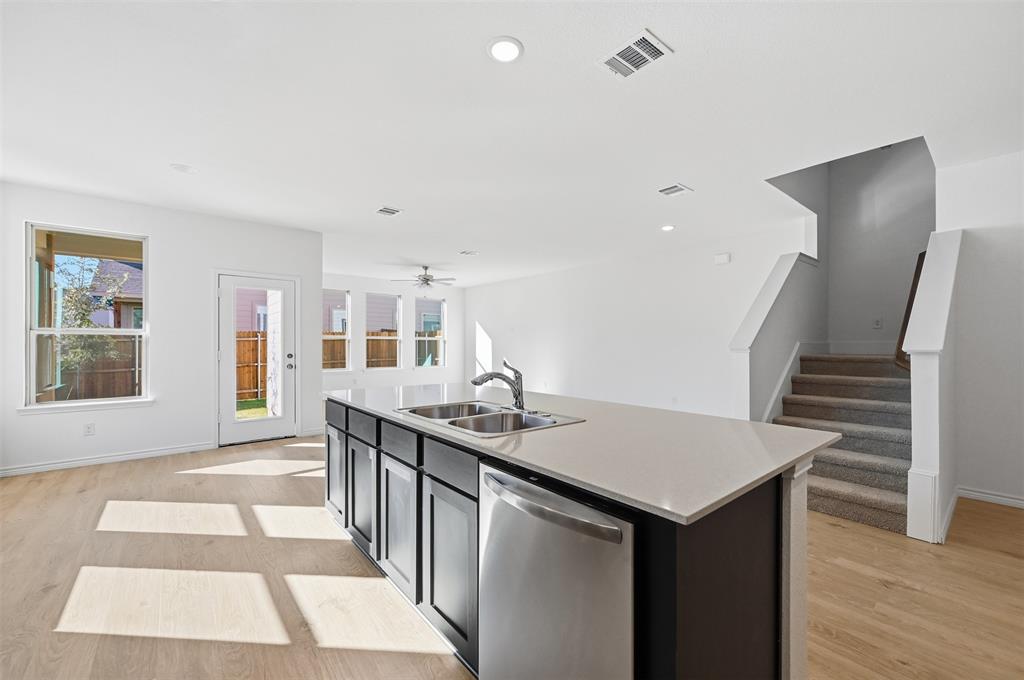 400 Wrangler Lane, Unit 400 Denton, TX 76209 - Photo 5 of 18 a kitchen with a sink and cabinets