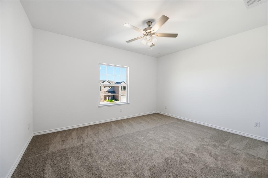 400 Wrangler Lane, Unit 400 Denton, TX 76209 - Photo 8 of 18 an empty room with windows and chandelier fan