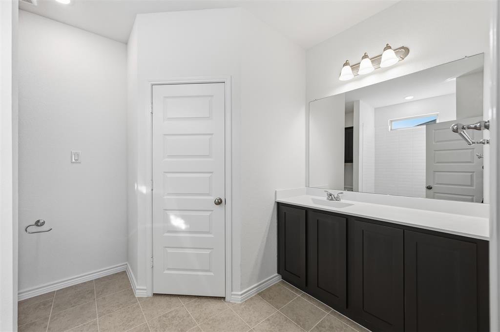 400 Wrangler Lane, Unit 400 Denton, TX 76209 - Photo 9 of 18 a bathroom with a double vanity sink and mirror