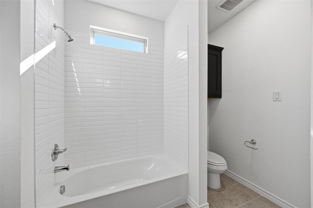 400 Wrangler Lane, Unit 400 Denton, TX 76209 - Photo 10 of 18 a bathroom with a toilet and a bathtub