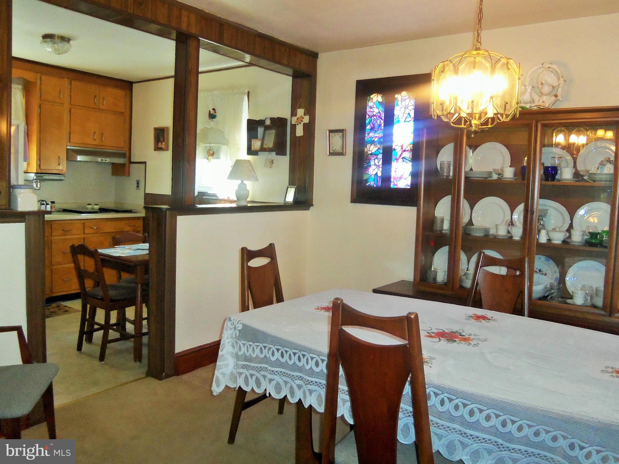 5574 Ashbourne Road Baltimore, MD 21227 - Photo 12 of 29 a dining room with furniture and chandelier or wooden floor
