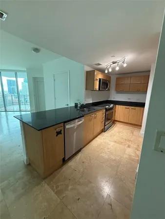 a kitchen with stainless steel appliances granite countertop a sink and a stove top oven
